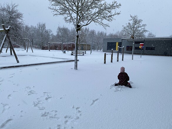 Kind auf dem Schulhof im Schnee